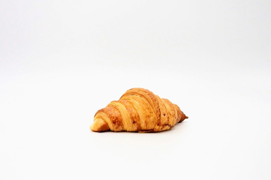 A single croissant against a light background